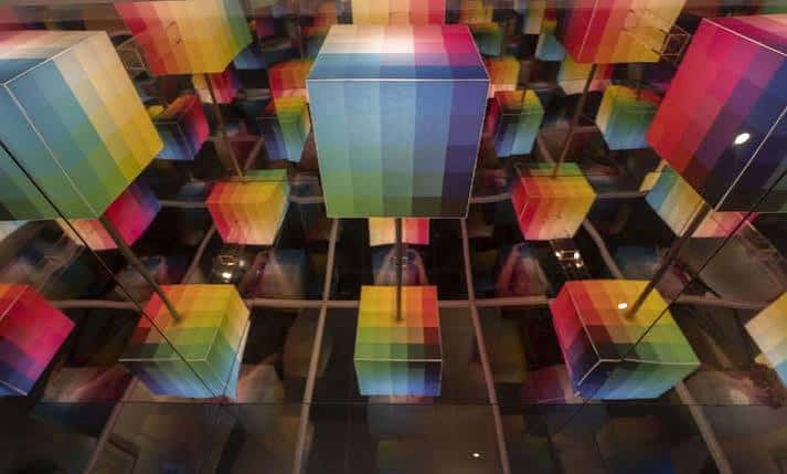 Instalación artística de cubos de colores suspendidos en el interior del museo