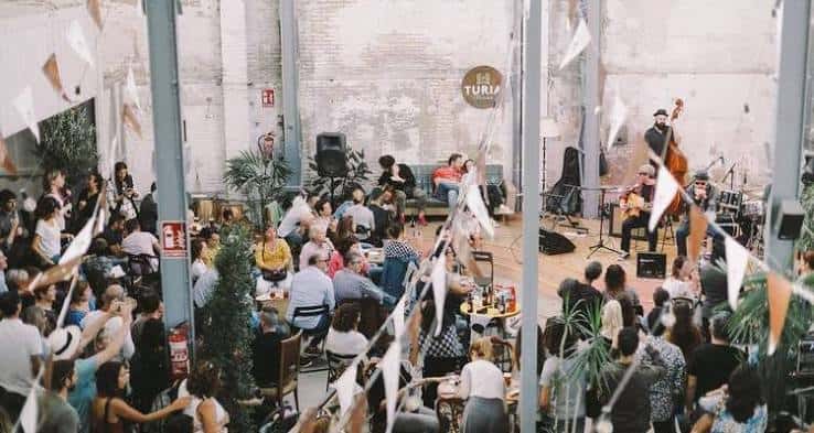 Evento musical en vivo con público sentado y decoración festiva