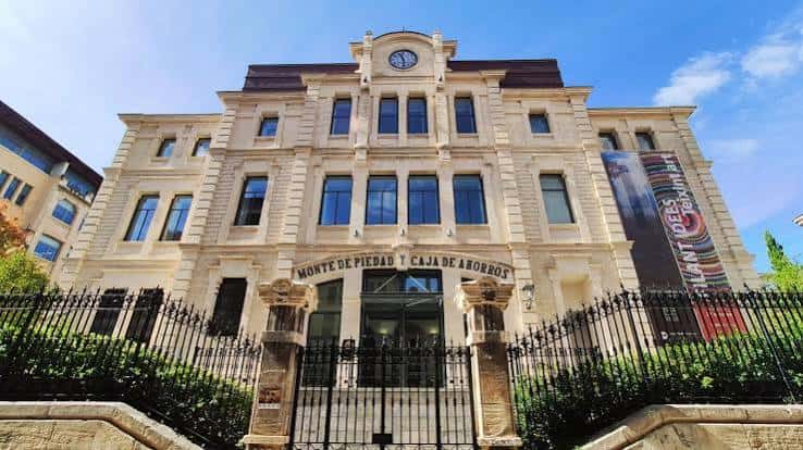Fachada principal del IVAM CADA Alcoi con el reloj y la inscripción 'Monte de Piedad y Caja de Ahorros'