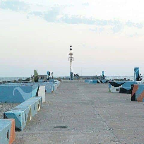 Vista del Espigón de la Térmica con estructuras pintadas y faro