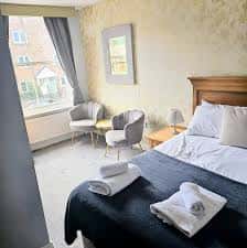 Habitación de hotel en The Waggon & Horses con cama doble, sillones modernos y vista a la calle