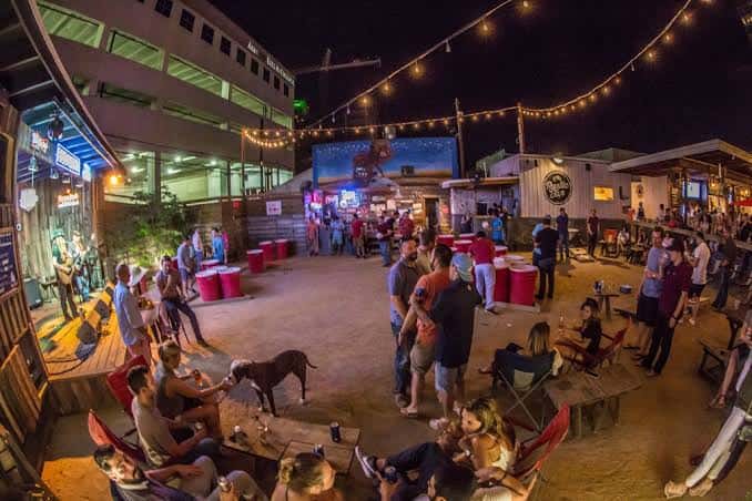 Ambiente nocturno del jardín con luces colgantes y zona de música en vivo