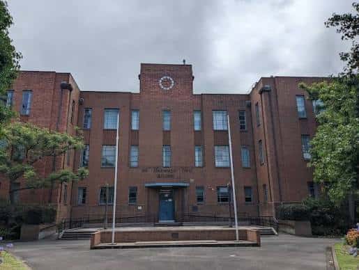 Fachada frontal del edificio histórico de TAFE NSW con banderas y escalinata