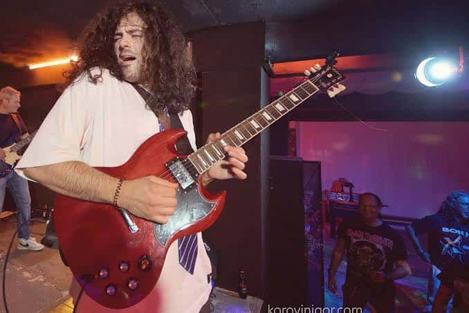 Músico tocando guitarra eléctrica en concierto en vivo