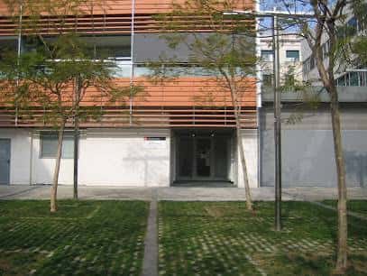 Fachada exterior contemporánea del espacio cultural con madera y vegetación en primer plano