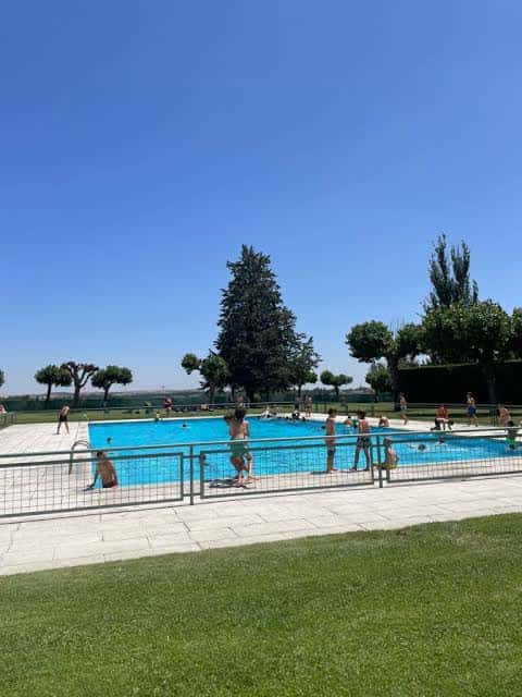 Piscina exterior al aire libre con personas disfrutando del sol