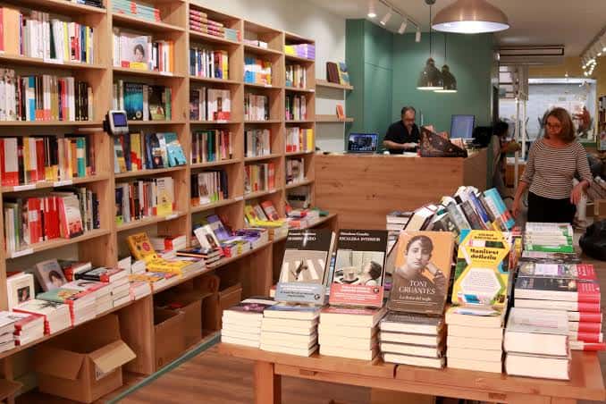 Interior acogedor de La Plural con estanterías llenas de libros y zona de lectura