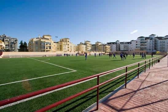 Campo de fútbol Suel en Fuengirola con césped artificial y jugadores en actividad