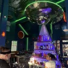 Interior del bar con iluminación neón y decoración temática espacial