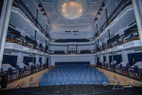 Vista general del interior del teatro con butacas azules y techo decorado