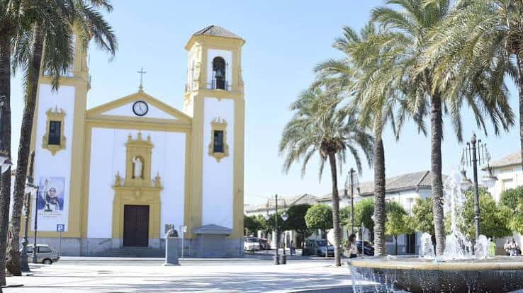 Vista exterior de la Parroquia San Vicente Ferrer con palmeras y fuente en primer plano