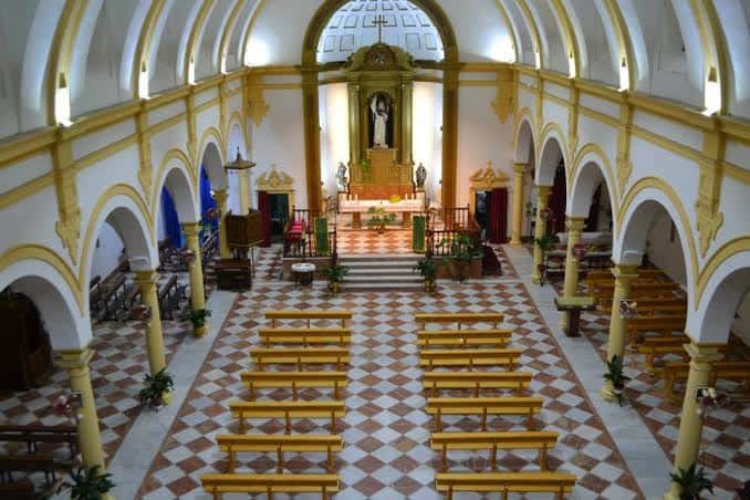 Interior de la nave central con arcos, columnas y altar mayor