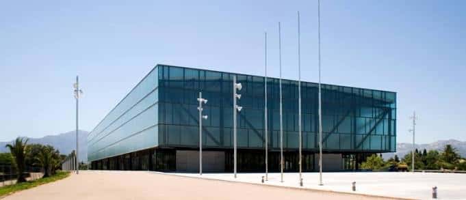 Vista exterior diurna del Pavelló Firal de Remolins con fachada de cristal y estructura metálica