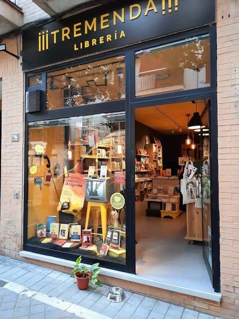 Vista exterior de la librería Tremenda en Granada con escaparate iluminado
