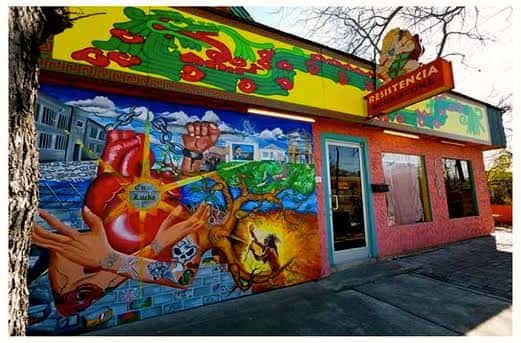 Fachada colorida de Red Salmon Arts con murales artísticos y letrero de Resistencia Bookstore