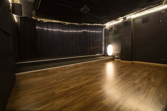 Sala de eventos con escenario y cortinas negras