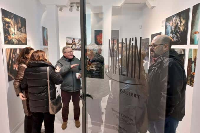 Vista del interior de la Malvin Gallery con visitantes y obras expuestas