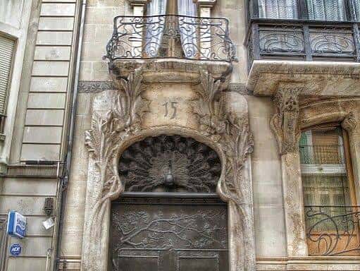 Entrada principal con puerta de hierro forjado y número 15