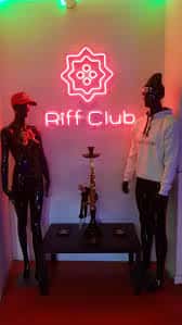 Escaparate decorado con neón y maniquíes en la entrada del club