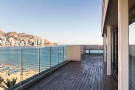 Terraza exterior del Centro Municipal El Torrejó con vistas al mar y pasarela de madera