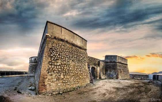 Amanecer sobre el Castillo de Carchuna con cielos dramáticos y silueta de las fortificaciones