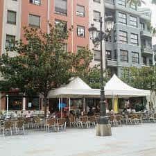 Plaza con carpas blancas y mesas dispuestas para eventos al aire libre
