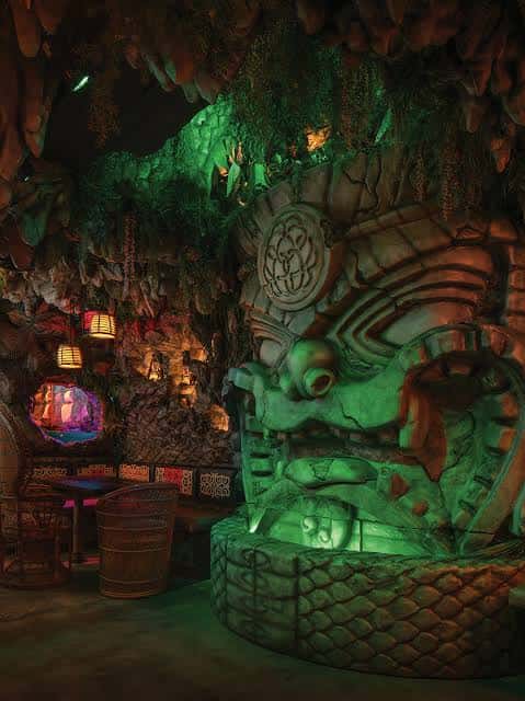 Interior del bar Tiki Tatsu-Ya con iluminación verde y decoración de cueva