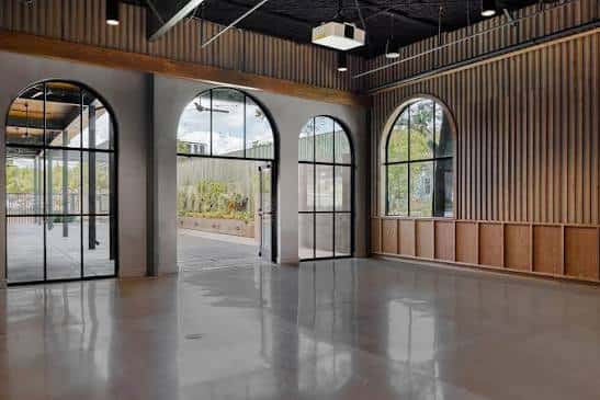 Interior espacioso con grandes ventanales arqueados y suelo pulido