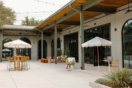 Terraza exterior amueblada con sombrillas y decoración para eventos