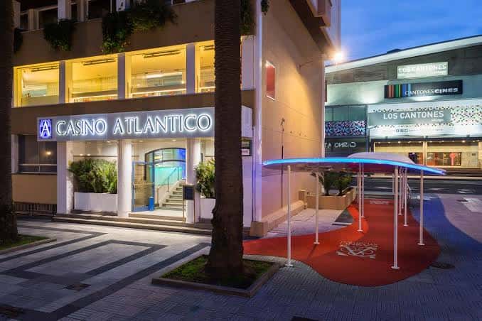 Fachada nocturna del Casino Atlántico con iluminación cálida y entrada principal