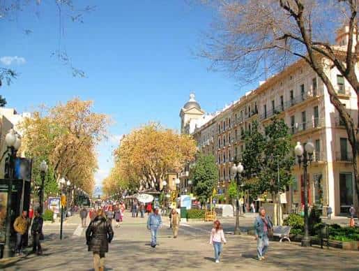 Paseo peatonal arbolado en la Rambla Nova con edificios históricos a ambos lados