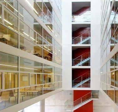 Vista interior del atrio central con escaleras rojas y pasillos acristalados