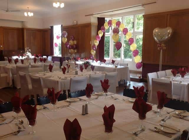 Salón decorado para evento con mesas y globos
