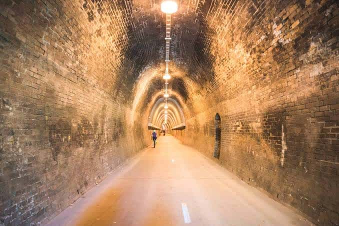 Interior del túnel de ladrillo iluminado por farolas colgantes