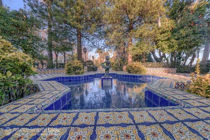 Vista del estanque central con mosaicos azules y la estatua de Clara Campoamor