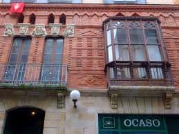 Detalle arquitectónico de edificio con balcones de madera y fachada de ladrillo rojo