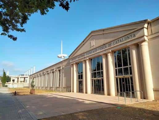 Entrada lateral del edificio con fachada clásica y cielo despejado