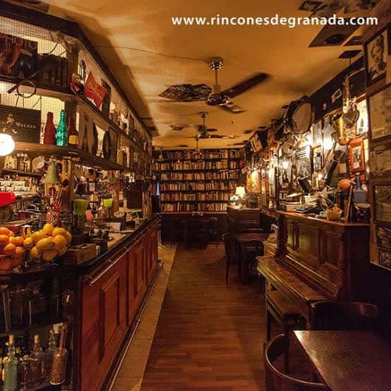 Interior acogedor del Bohemia Jazz Café con barra de madera, estanterías llenas de libros y decoración bohemia