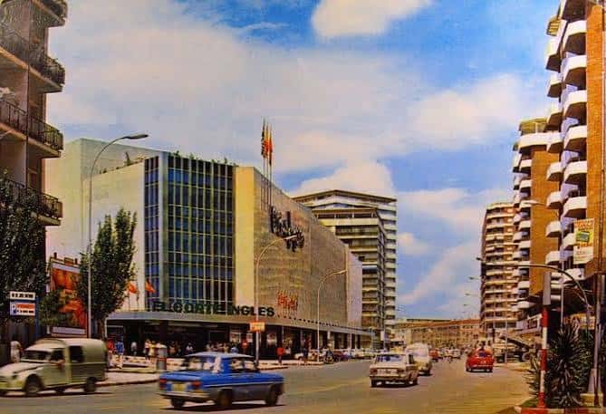 Vista histórica de la Avenida Libertad con edificios modernos y tráfico de época