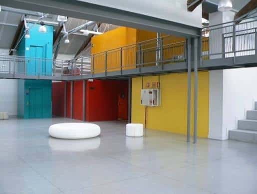 Interior del espacio con zonas coloridas y estructura industrial moderna
