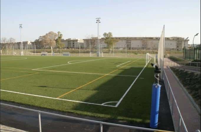 Amplia vista del campo de fútbol con líneas marcadas y gradas al fondo