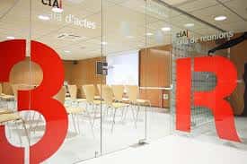 Sala de reuniones o eventos con mobiliario moderno y señalización en cristal