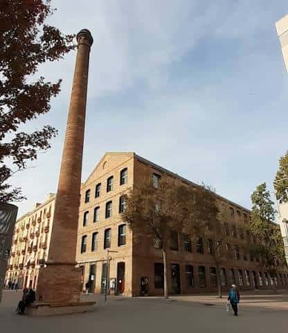 Vista exterior del edificio de Can Saladrigas con su característica chimenea industrial