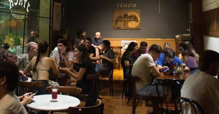 Vista del interior de la cafetería Ítaca llena de gente socializando