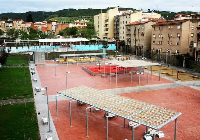Plaza central del parque con estructuras de sombra y áreas recreativas