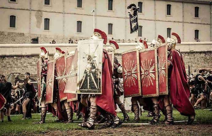 Grupo de legionarios romanos con escudos y cascos en formación durante las fiestas
