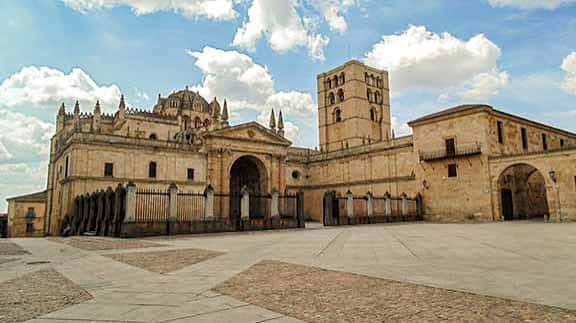 Fachada principal de la catedral con plaza frontal y cielo nublado