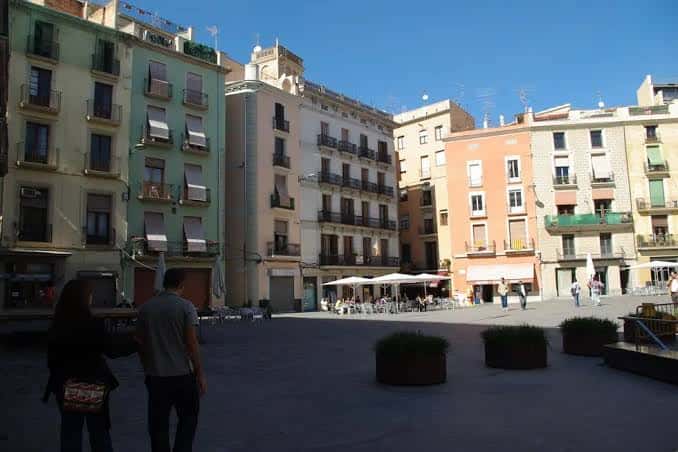 Vista general de la Plaça del Raval con edificios históricos y terrazas al aire libre