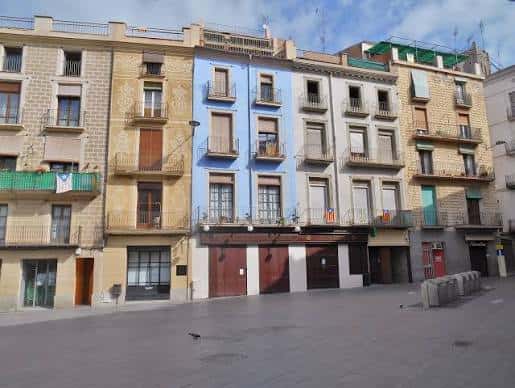 Fachada de edificios tradicionales en la Plaça del Raval con balcones y colores pastel