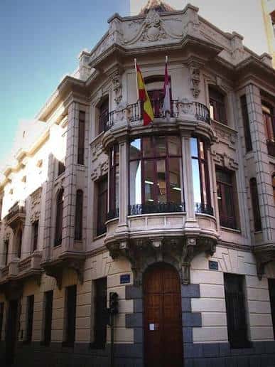 Fachada principal del Archivo Histórico Provincial de Albacete con balcones ornamentados y banderas